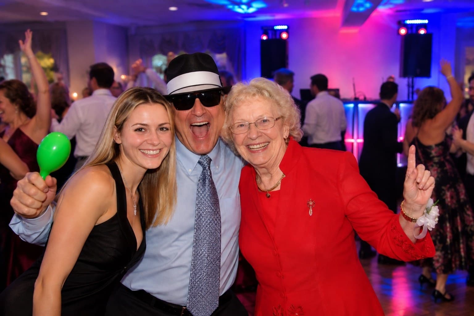 Wedding guests dancing with festive party props at the reception