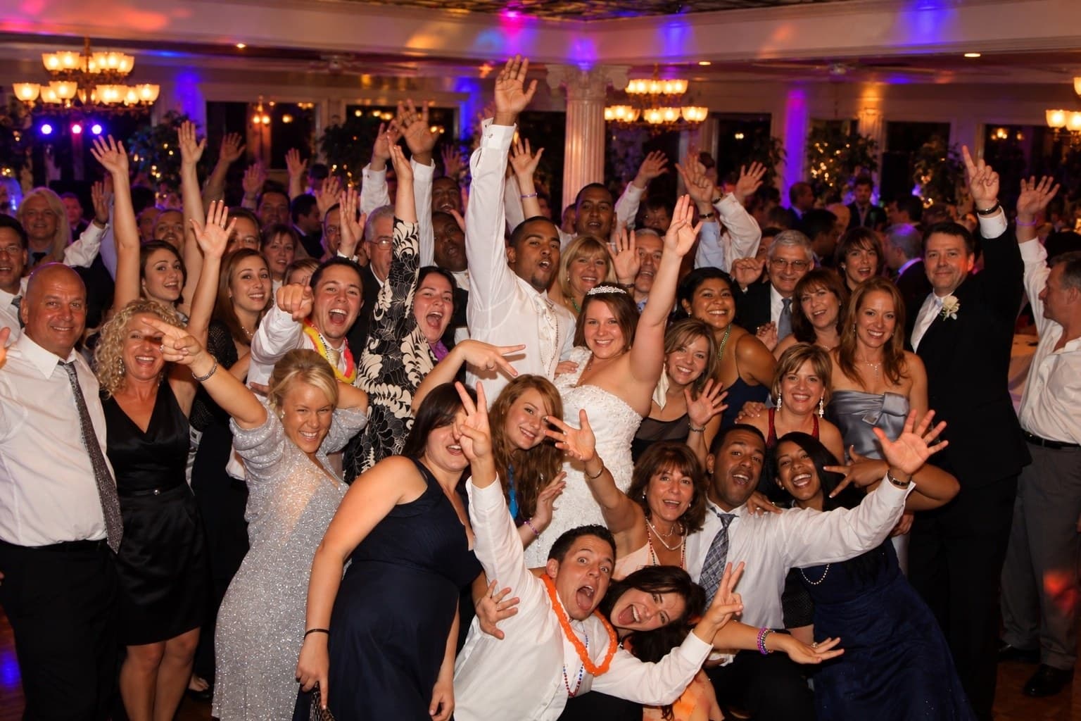 Large wedding group celebrating together at the reception